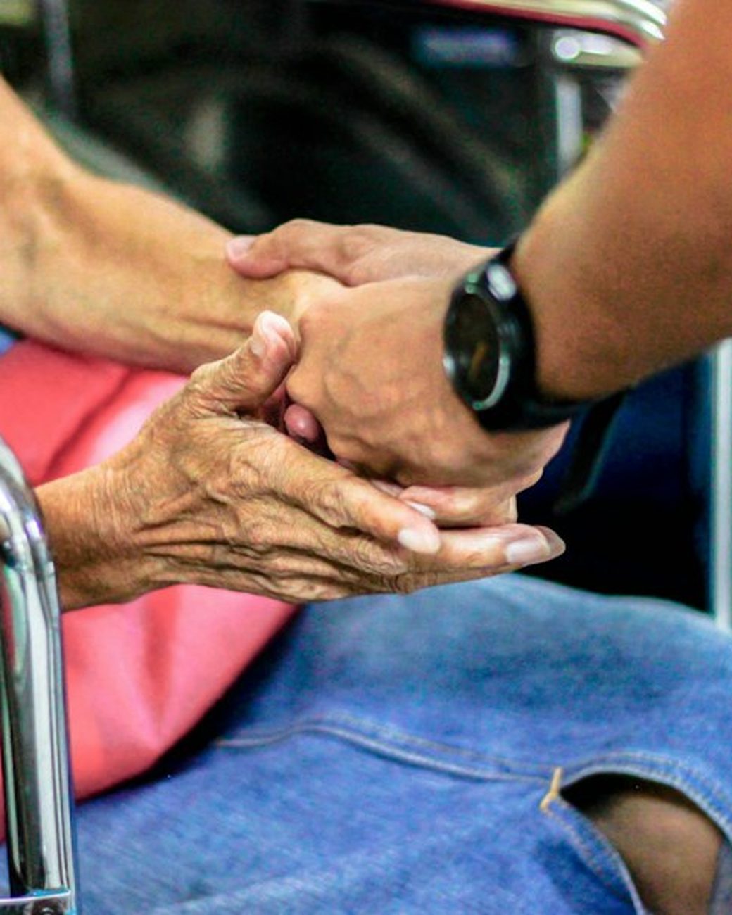 A younger hand holding an older person’s hands